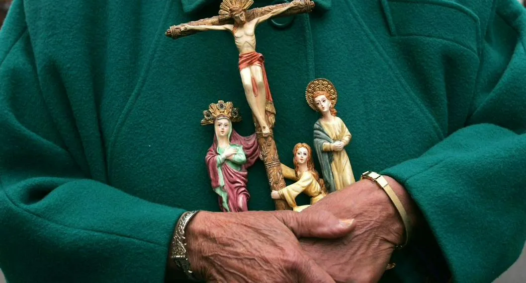 Persona con figuras de santos a propósito de qué se celebra cada día de Semana Santa. 