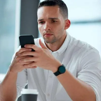 Foto de hombre preocupado viendo su celular, en nota de Colpensiones anunció que no funcionará sede electrónica ni app en Semana Santa.