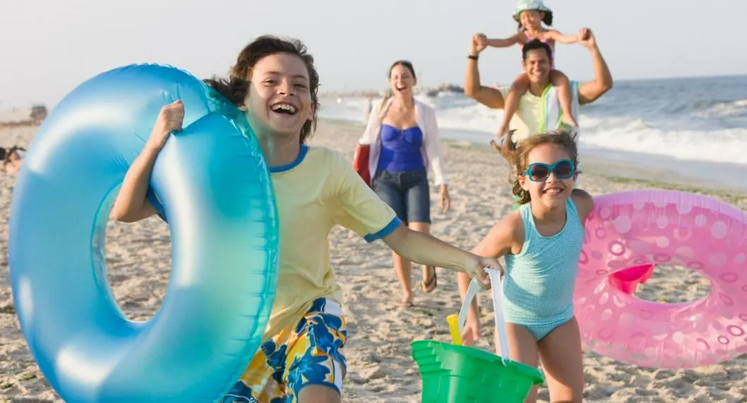 Foto de niños jugando en la playa, para ilustrar artículo sobre cuándo son las vacaciones de mitad de año en Colombia.