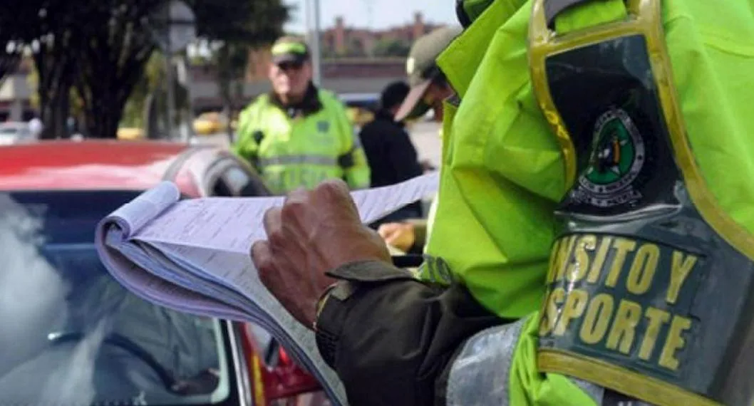 Foto de policía poniendo una multa de tránsito, a propósito del precio por no tener documentos al día de carro