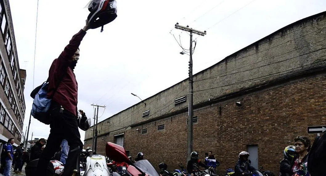 Motociclista en Bogotá con casco en la mano ilustra nota sobre grupo de moteros que recupera motos robadas en Bogotá.