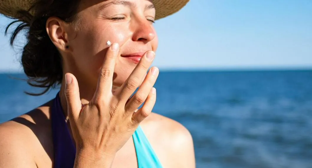 Mujer aplicándose el protector solar a propósito de cómo elegir al correcto para su piel.