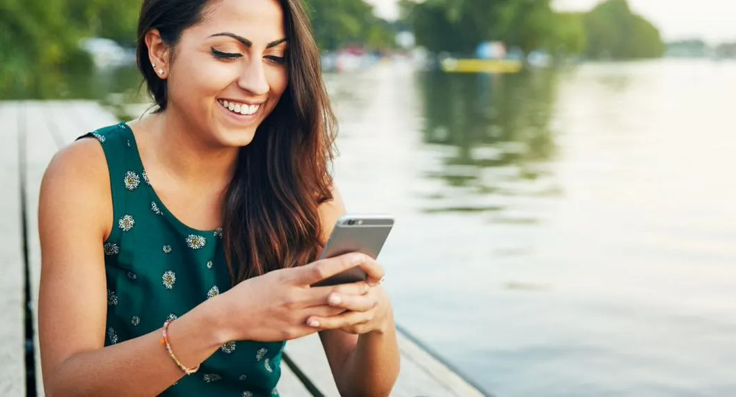 Persona feliz con su celular usado a propósito de las recomendaciones que debe considerar antes de comprarlo.