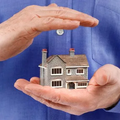 Foto de una persona sosteniendo una casa, para ilustrar artículo sobre cómo 