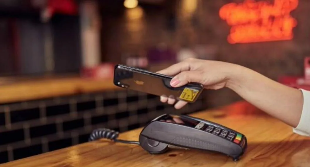 Foto de datáfono con tarjeta de crédito, a propósito de cómo pagar con tasas de interés más bajas.
