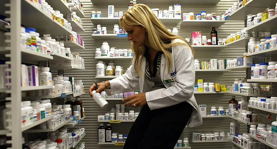 Farmaceuta eligiendo medicamentos, algunos de los cuales escasean en Colombia por estos días.