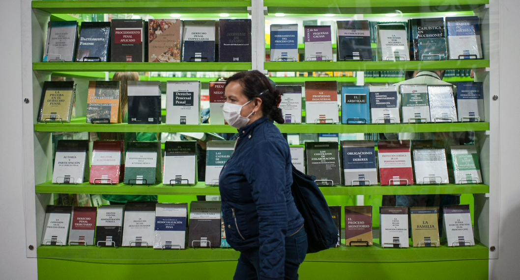 Persona caminando frente a un estante de libros, para ilustrar artículo sobre los mejores días para ir a la Feria del Libro 2023 en Bogotá.
