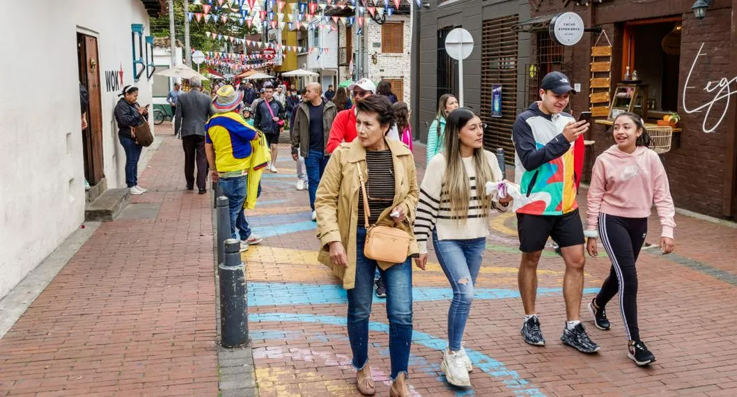 Personas paseando en una calle a propósito de cuántos festivos hay en Colombia.