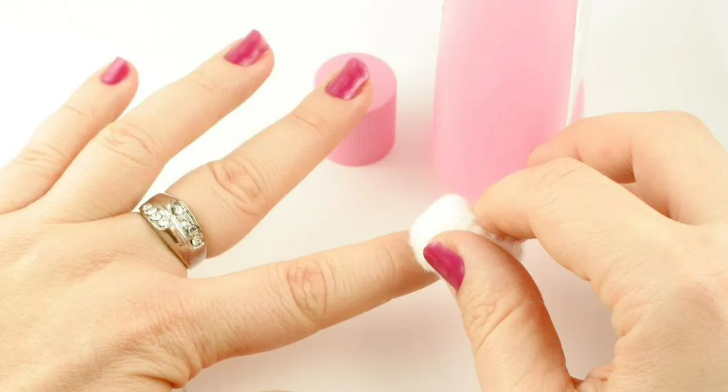 Mujer despintándose las uñas a propósito de cómo usar el quitaesmalte para el hogar.