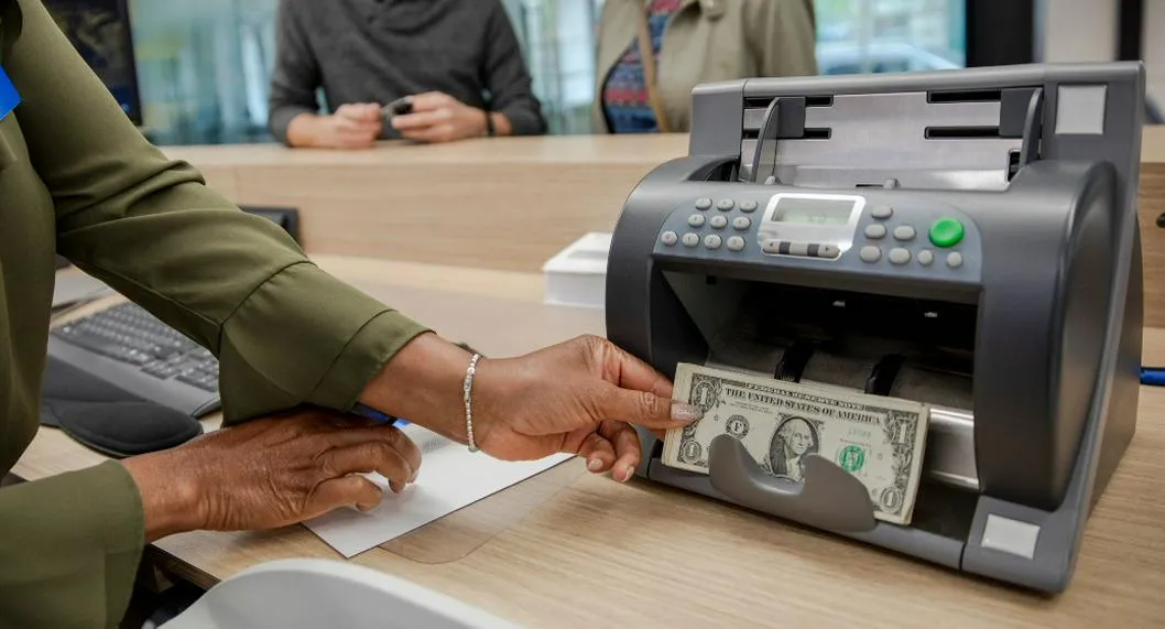 Foto de una contadora de billetes con dólares, para ilustrar artículo sobre a cómo amaneció el precio del dólar en Colombia. 