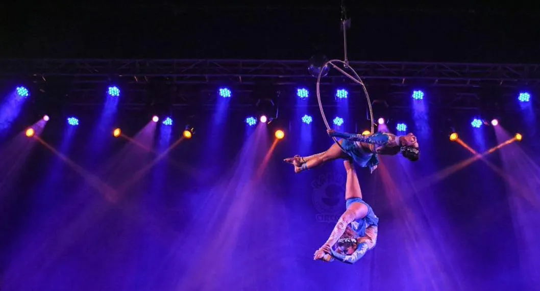 Acróbatas de circo en el aire en medio de actuación ilustra nota sobre muerte de una mujer que cayó mientras hacia acrobacia.