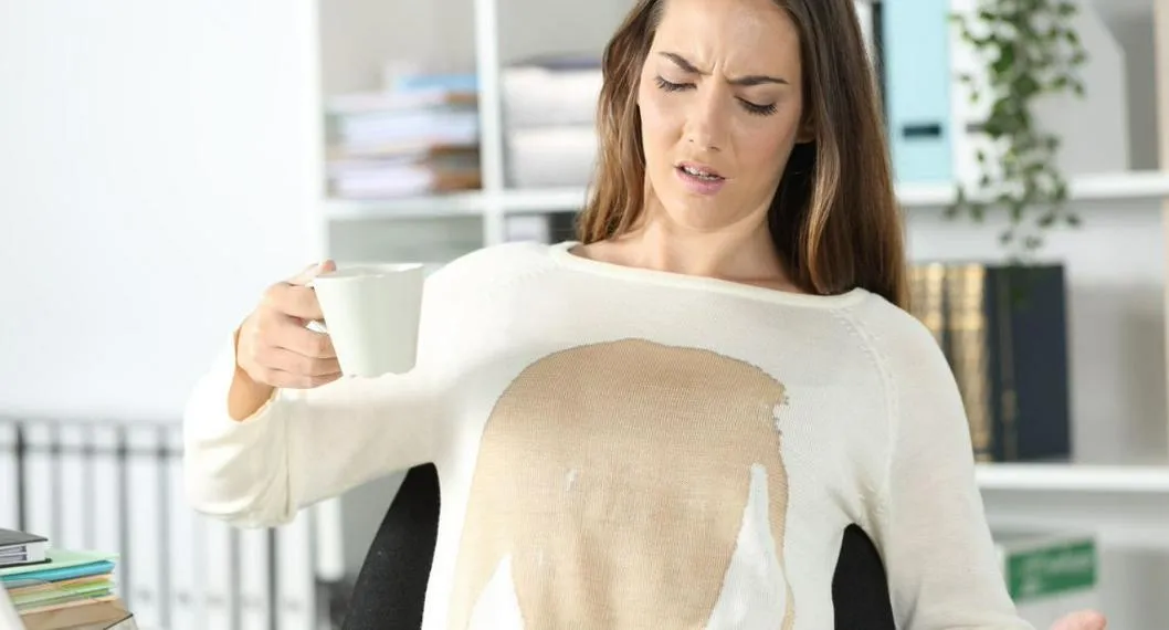 Persona con mancha de café a propósito de cómo quitarla.