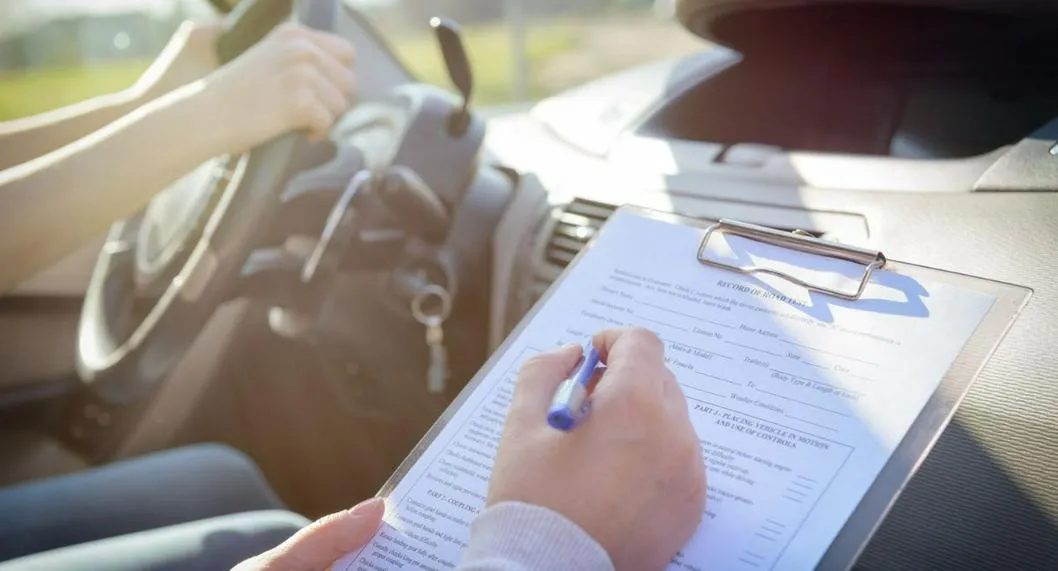 Persona conduciendo siendo evaluado por un instructor ilustra nota sobre enfermedades por las que restringen la licencia de conducción.