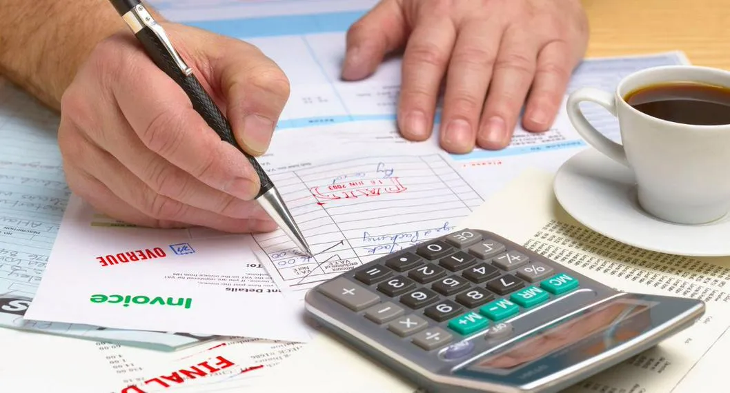 Persona haciendo cálculos por impuestos ilustra nota sobre la fecha límite de pago del impuesto predial en Bogotá 2023.
