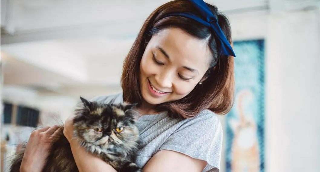 Mujer con gato a propósito de las prácticas que podrían afectar a su mascota.