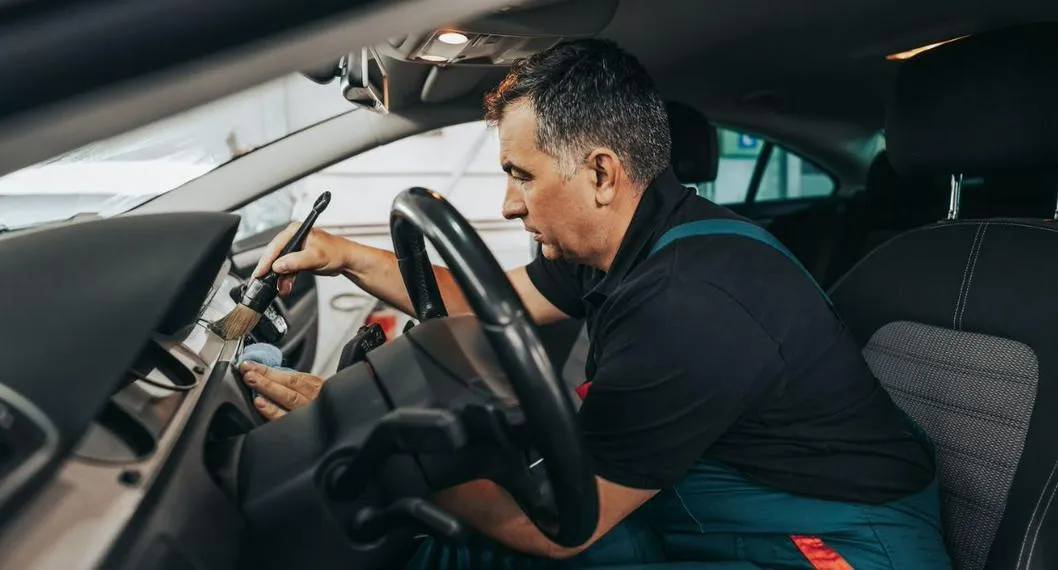 Señor limpiando el carro a propósito de cómo mantener el interior del vehículo limpio.