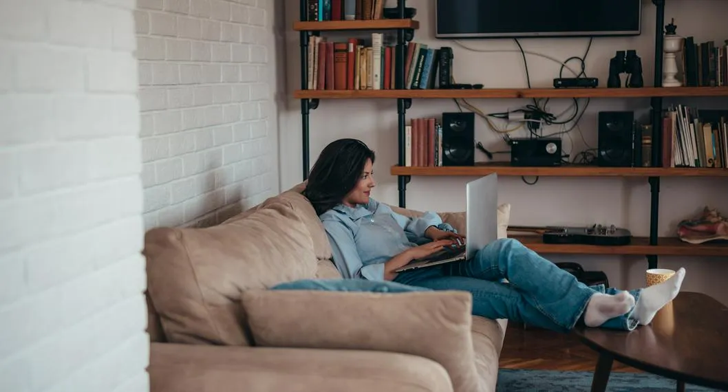 Mujer con su computador a propósito de cómo mantener la señal del wifi en casa.