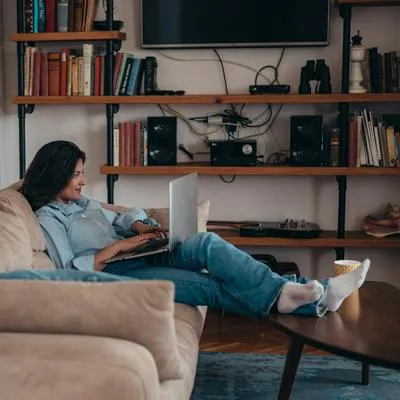 Mujer con su computador a propósito de cómo mantener la señal del wifi en casa.