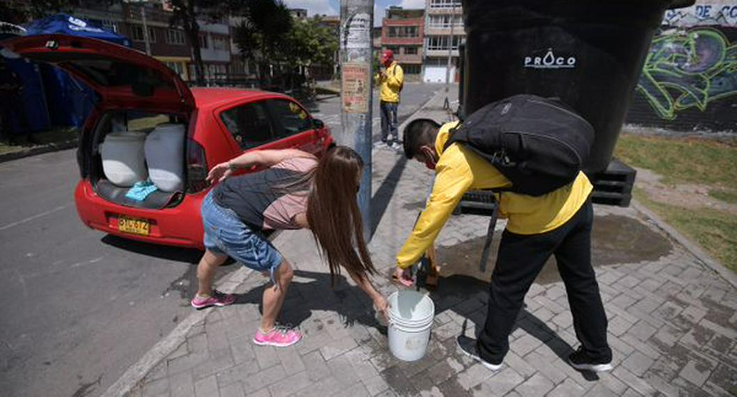 Ciudadanos en Suba haciendo fila para recolectar agua por daño en tubería