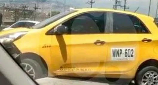 Taxi se cayó de la grúa que lo llevaba y quedó sobre el separador en Medellín.
