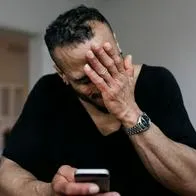 Foto de hombre con teléfono a propósito de error WhatsApp con link wa.me/settings, qué y cómo daña su celular