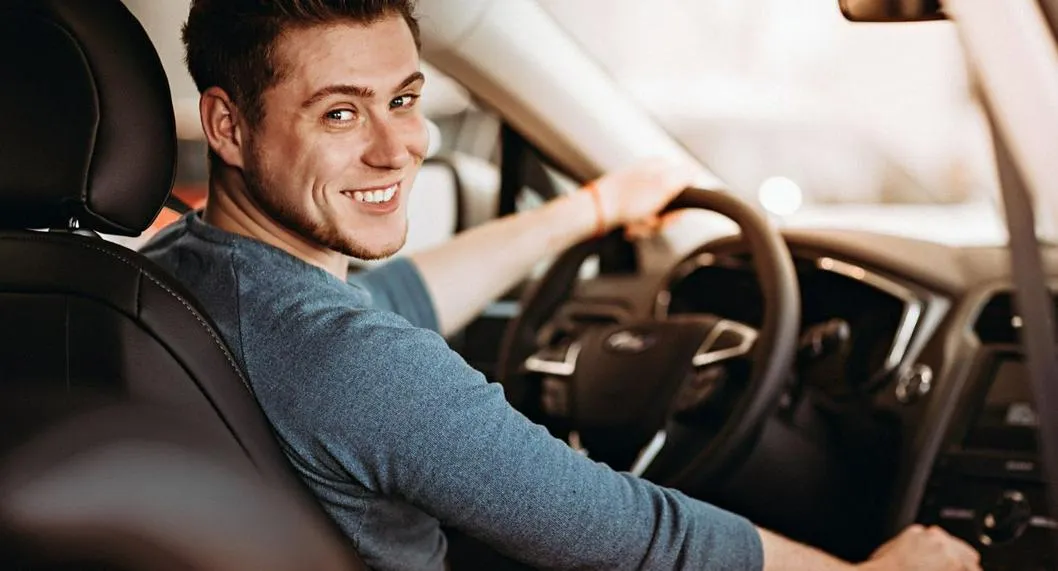 Persona feliz en el carro a propósito de cómo mantener el olor a nuevo en el vehículo.
