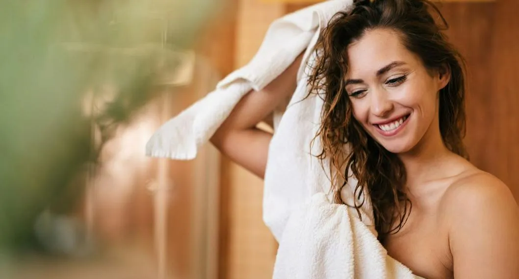 Persona lavándose el cabello a propósito de cómo reparar las puntas abiertas.