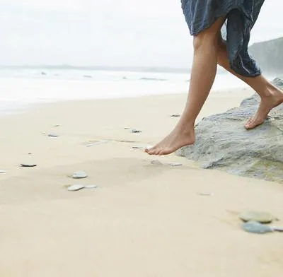 Mujer en la playa. En relación con historia de joven que se enfermó por la arena.