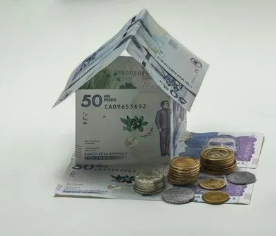 Casa con billetes. En relación con los créditos de vivienda y la asesoría de IA.