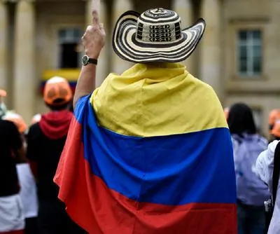 Persona con bandera de Colombia en marcha.