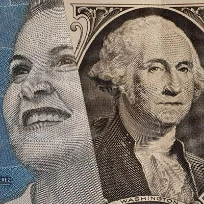 Dólar con billetes colombianos, por datos de inflación y tasas de interés en Colombia