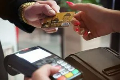 Persona con tarjeta en la mano. En relación con estafas.