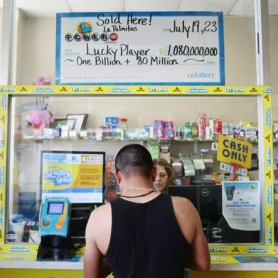 Persona comprando en el puesto que vendió el boleto ganador del Powerball, en nota sobre que vendedora recibirá un millón de dólares