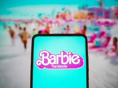 Celular con la película de Barbie. En relación con el mensaje que hay detrás.