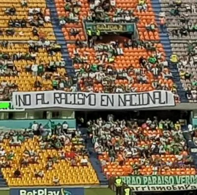 Bandera en la tribuna oriental del estadio Atanasio Girardot contra el presunto caso de racismo en Atlético Nacional.