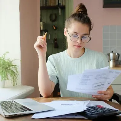 Foto de mujer analizando sus finanzas ilustra nota sobre consejos para pagar deudas