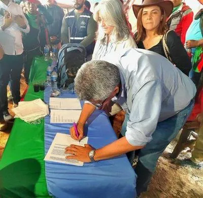 Ministro del Interior firmando acuerdo con indígenas para levantar paro en vía Panamericana. 