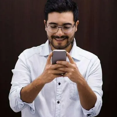 Foto de persona frente a celular, en nota de que Nubank habla de futuro y mete miedo a Davivienda, Bancolombia y más en Colombia