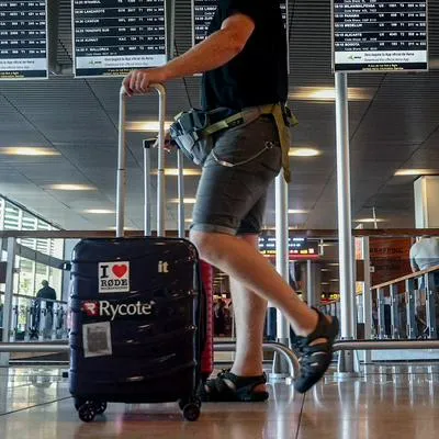 Hombre en aeropuerto de Madrid, España, con su maleta, en nota sobre países en dodne los colombianos más pierden el equipaje