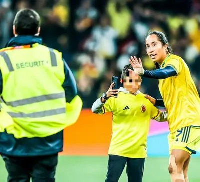 Mayra Ramírez, delantera de la Selecicón Colombia Femenina, junto a niño que entró a pedirle una foto.