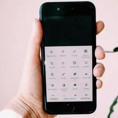 Hombre sosteniendo celular con Snapseed, una de las cinco mejores aplicaciones para editar fotos en móvil.