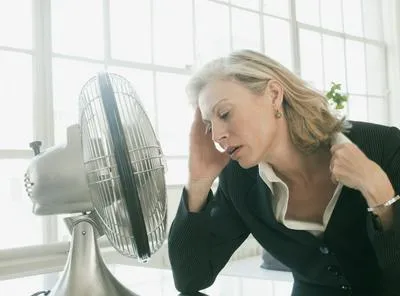 Mujer con ventilador. En relación con ola de calor en Medellín.