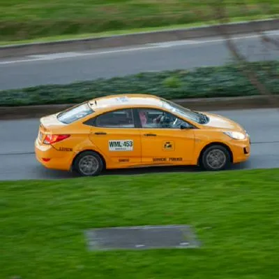 A taxi roams on the 26th avenue in Bogota during a rainy afternoon using protective face masks to prevent the spread of the novel Coronavirus pandemic. In Bogota, Colombia, on January 4, 2020. (Photo by Sebastian Barros/NurPhoto via Getty Images)