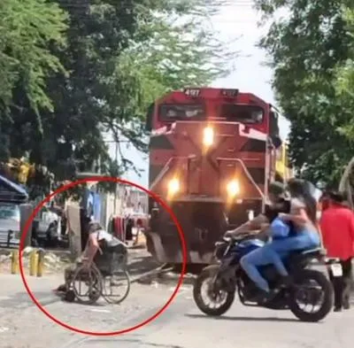 Hombre en silla de ruedas que compite contra un tren, se queda atascado en la vía y por poco es arrollado.