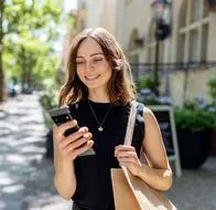 Mujer usando un celular, en el que puede editar videos con estas aplicaciones.