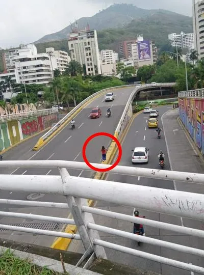 Mujer que camina por separadores de Cali.