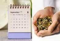 Calendario y manos con dinero. Imagen de referencia. 