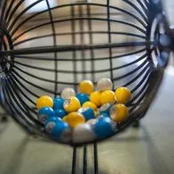 Bolas de lotería en una estructura metálica que se utiliza para mezclarlas, contextualizando la respuesta de la inteligencia artificial sobre las loterías más fáciles de ganar en Colombia