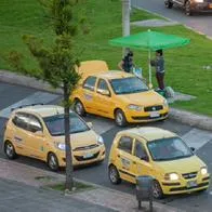 Taxi drivers wait on their cars for rides during a rainy afternoon using protective face masks to prevent the spread of the novel Coronavirus pandemic. In Bogota, Colombia, on January 4, 2020. (Photo by Sebastian Barros/NurPhoto via Getty Images)