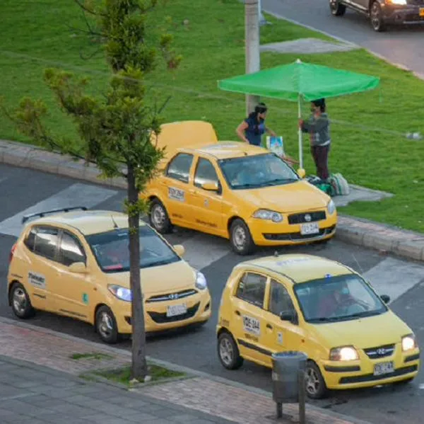 Taxi drivers wait on their cars for rides during a rainy afternoon using protective face masks to prevent the spread of the novel Coronavirus pandemic. In Bogota, Colombia, on January 4, 2020. (Photo by Sebastian Barros/NurPhoto via Getty Images)